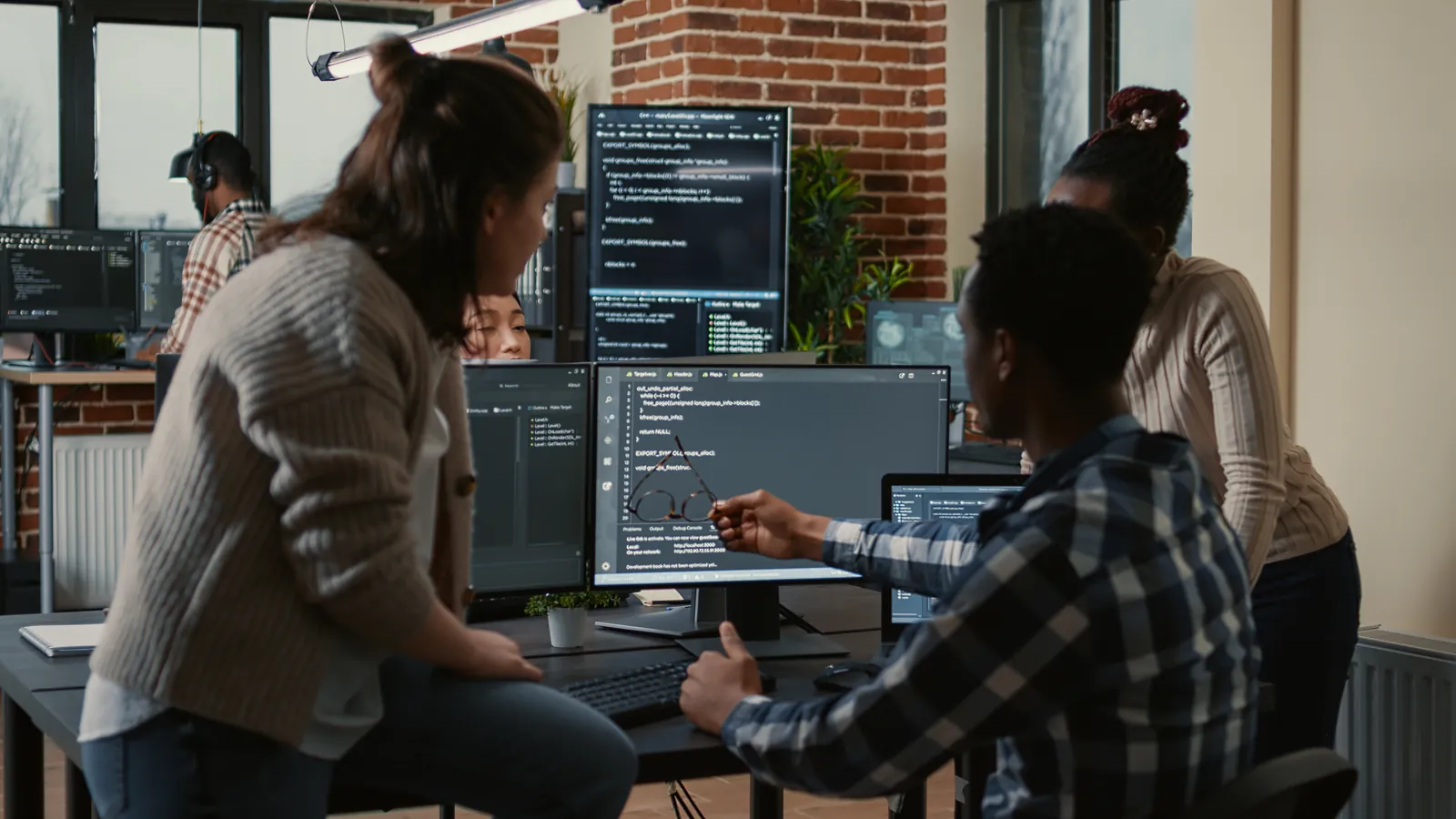 Équipe de développeurs qui travaille devant des écrans de code